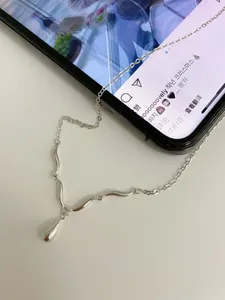 Detailed view of polished S925 sterling silver wavy chain with teardrop pendant