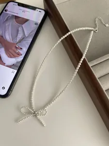 Close-up of S925 sterling silver bow pearl necklace with fine white freshwater pearls
