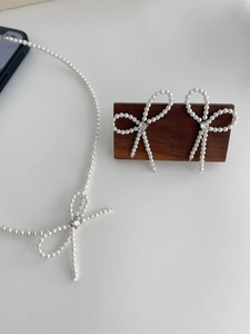 Detail of S925 silver pearl bow jewelry set with necklace and matching earrings