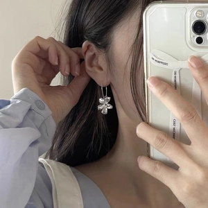 Spiegel-selfie met de elegante bloemvormige 925 zilveren oorknop op het oor van een model