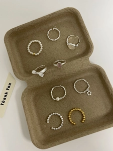 Close-up of S925 sterling silver ring set with pearls and beads in a vintage tray