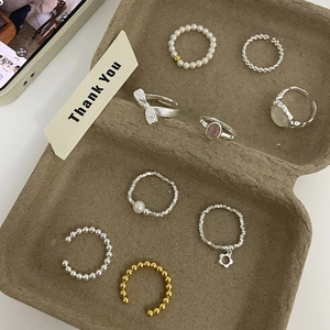 Minimalist S925 sterling silver beaded rings with pearls and bow charms on tray