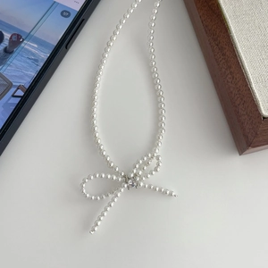 Elegant white pearl necklace with a delicate pearl bow pendant and sparkling zircon