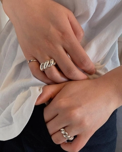 Detailaufnahme eines klobigen Croissant-Drehrings aus Sterlingsilber am Finger