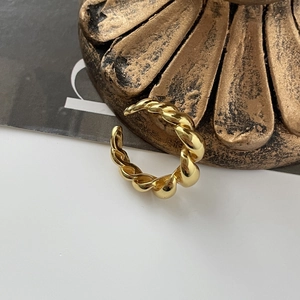 Makroaufnahme eines goldenen Rings mit gedrehtem Seilmuster und verstellbarem Design