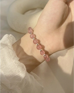 Close-up of pink strawberry crystal bead bracelet with silver accents on female wrist