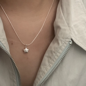 Minimalist S925 sterling silver star pendant necklace with smile face worn by a model