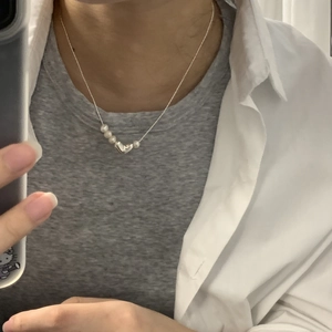 Detailed view of S925 silver heart pendant and freshwater pearls on a delicate necklace