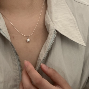 Close-up of S925 silver star pendant necklace on a neck with elegant snake chain details