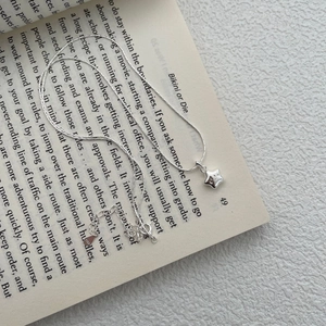 Close-up of S925 sterling silver star pendant with smiling face on snake bone chain