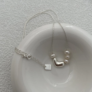 Detail view of S925 sterling silver heart pendant and fresh water pearls on a chain