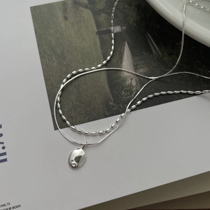 Detail of S925 silver double layer necklace with bean chain and oval pendant