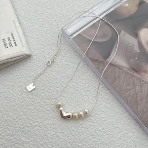 Detailed macro of S925 silver heart necklace with natural freshwater pearls and clasp