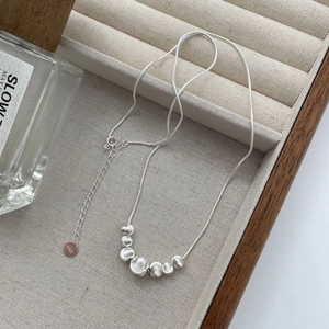 Elegant S925 sterling silver frosted bead necklace on a beige velvet jewelry tray