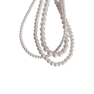 Classic layered 925 silver pearl necklace with mixed size white pearls on a plain background