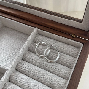 Nahaufnahme von S925 Sterling Silber Creolen mit poliertem Finish auf grauem Leinen