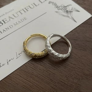 Detailed close-up of woven wheat ear pattern rings with crystals on vintage card