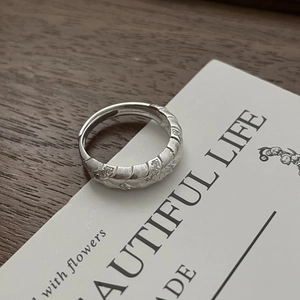 Macro shot of silver wheat ear texture with sparkling diamonds on a brushed ring