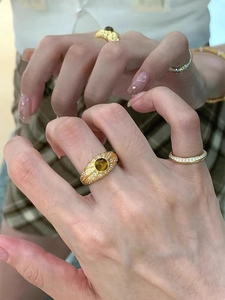 Gros plan sur une bague oeil de tigre en or brossé avec un anneau serti de diamants