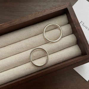 Détail de deux bagues minimalistes en argent sterling S925 sur un écrin à bijoux en bois