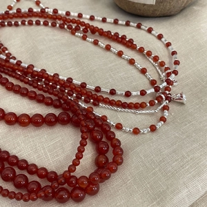 Elegant S925 sterling silver necklace featuring vibrant red agate beads and small bell charms