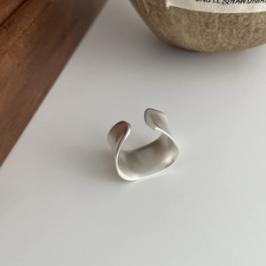 Macro shot of wide matte S925 sterling silver open ring with brushed metal texture