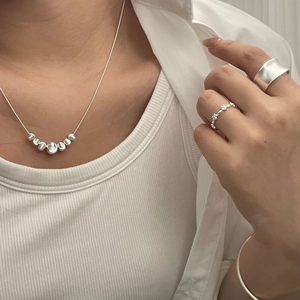 Detailed view of S925 silver necklace and rings set on a model for a minimalist look