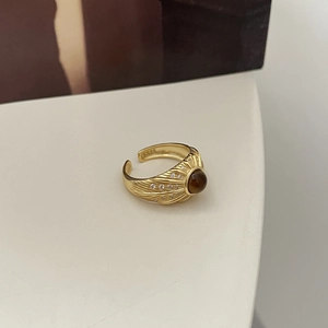 Détail d'une bague vintage en or avec oeil de tigre et anneau réglable gravé S925