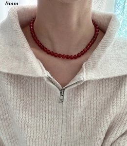 Detail of 8mm red agate bead necklace on model with elegant polished glass luster finish