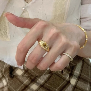 Détail d'une bague vintage en or avec pierre oeil de tigre et zircons sur le mannequin