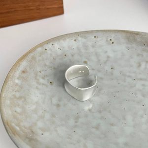 Detail showing matte brushed S925 sterling silver ring on ceramic tray