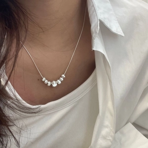 Close-up of S925 silver beaded necklace with frosted cat-eye beads on female neck