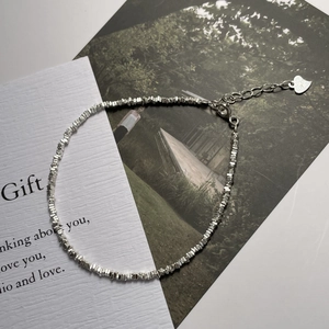Gros plan sur un bracelet en argent S925 avec perles concassées et breloque en cœur