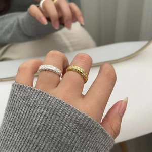 Detail view of woven texture silver and gold rings with sparkling zircon inlay