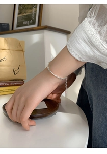 Gros plan d'un délicat bracelet en argent fin S925 avec pendentif cœur au poignet