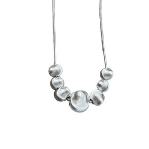 Minimalist S925 sterling silver necklace featuring seven gradient polished metal beads