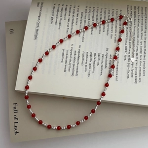 Macro shot of S925 sterling silver red agate bead necklace with heart tag on books