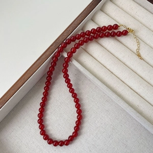 Close-up of red agate beaded necklace with gold lobster clasp and adjustable chain