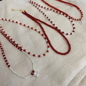 S925 sterling silver red agate bead necklace with clover pendant on linen background