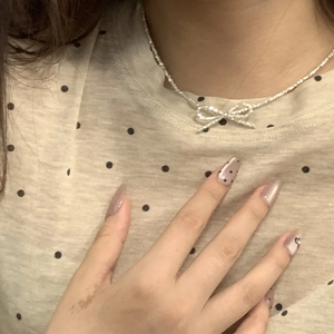 Detail of S925 silver bow necklace with shimmering cubic zirconia on neck