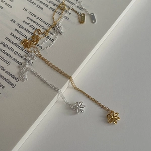 Détail macro du pendentif fleur en argent S925 avec poinçon gravé sur un livre