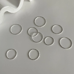 Artistic overhead view of S925 sterling silver hammered rings on a grey background