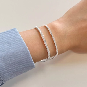 Close-up of stacked S925 sterling silver tennis bracelets with white zircon stones