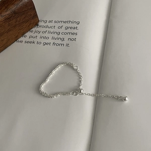 Detailed shot of minimalist S925 sterling silver chain ring with hanging metal bead
