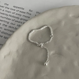 Minimalist S925 sterling silver adjustable tassel ring on grey ceramic tray