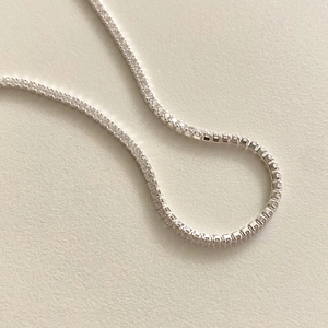 Macro shot of a fine S925 sterling silver tennis chain bracelet with white cubic zirconia