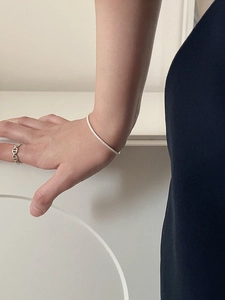 Close-up of S925 sterling silver tennis bracelet and geometric ring set on female model
