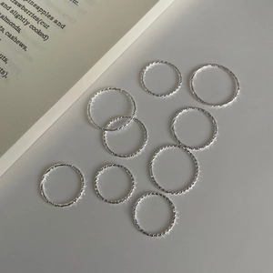 Detailed macro of S925 sterling silver rings with textured finish and light refraction