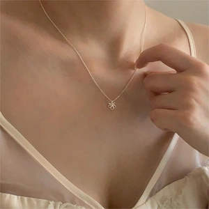 Collier avec pendentif fleur en argent sterling S925 porté au cou par un mannequin