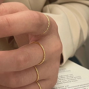 Close-up of golden hammered S925 silver rings with delicate faceted texture on fingers